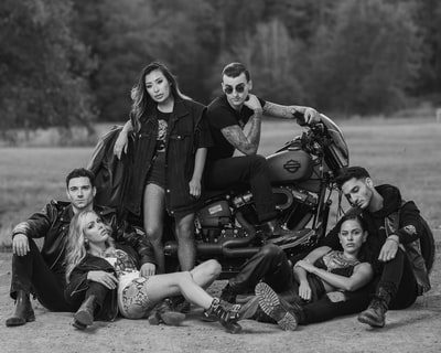 grayscale photo of 3 women sitting on motorcycle